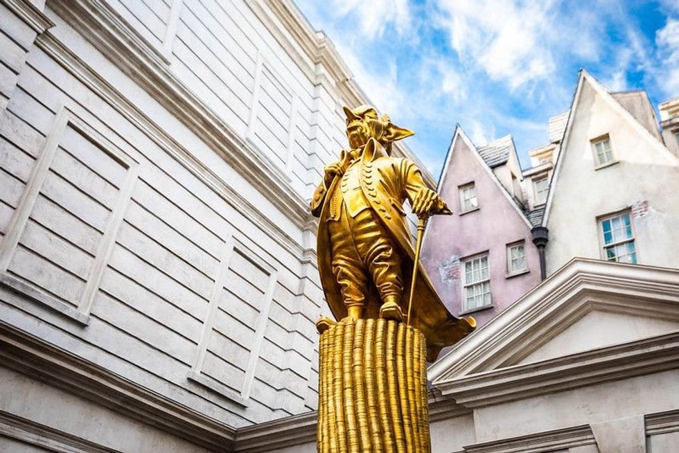 Golden statue of Gringotts Goblin on coins