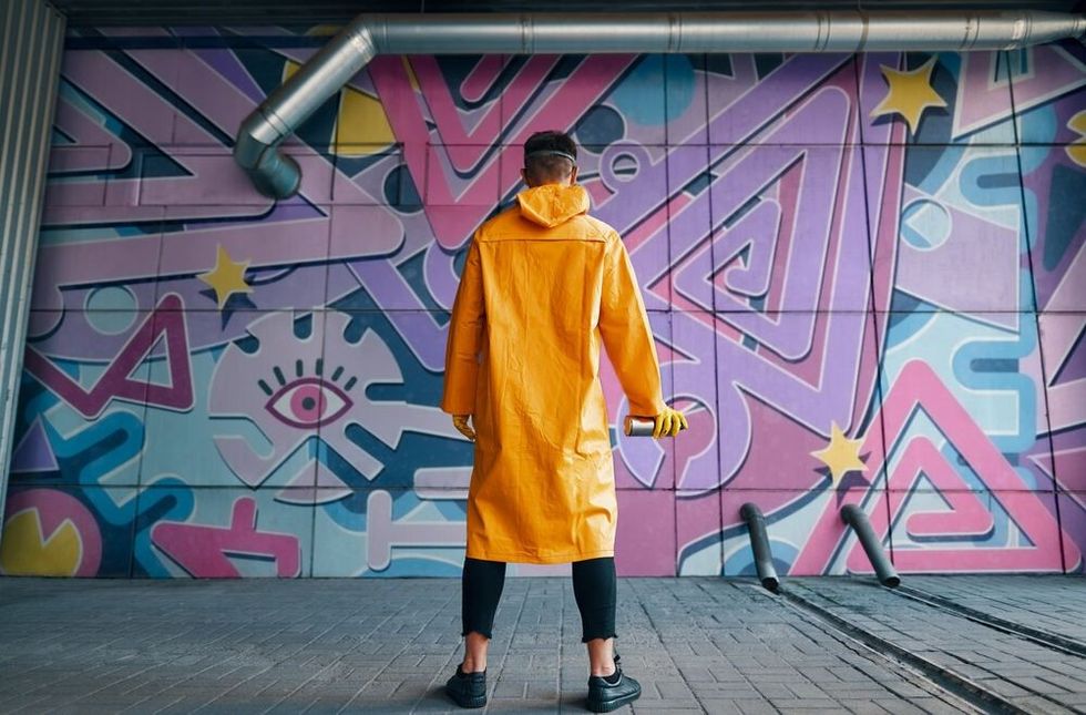 graffiti painter looking to the wall with his paintings