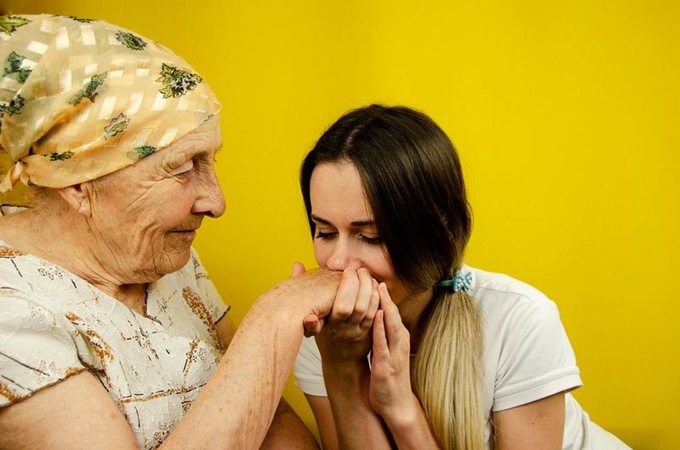 Granddaughter kissing grandmother's old hand