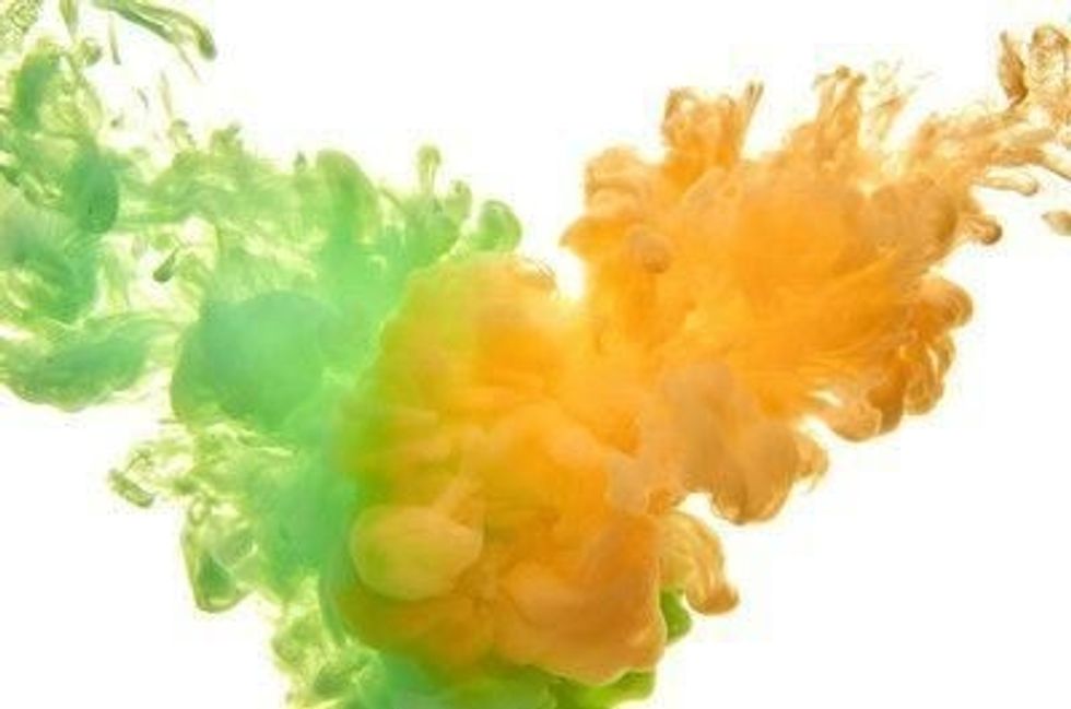 Green and orange acrylic ink in water on white background