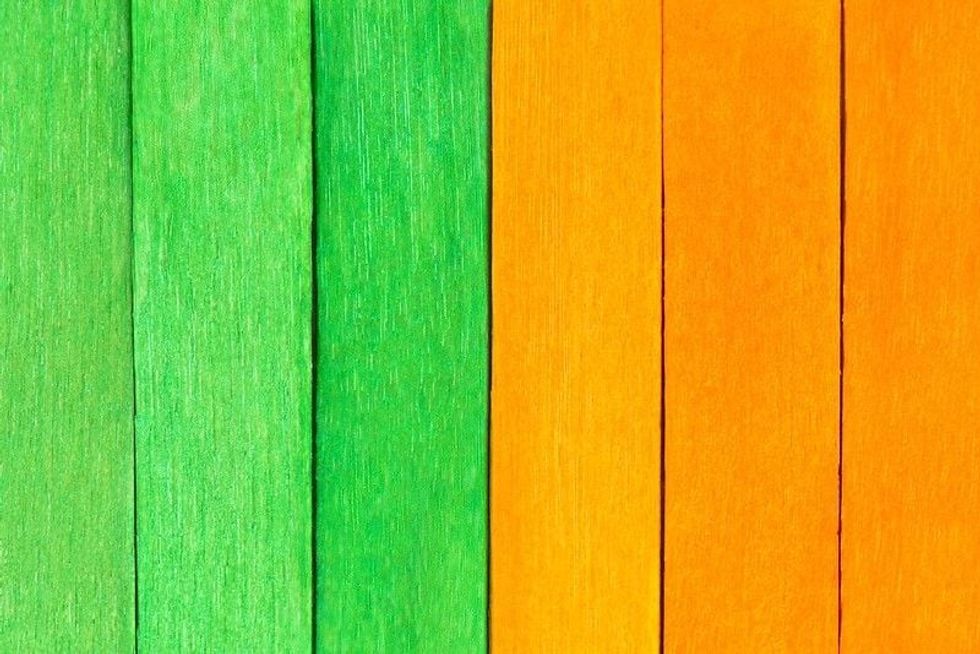 Green and orange painted wooden boards in a row.