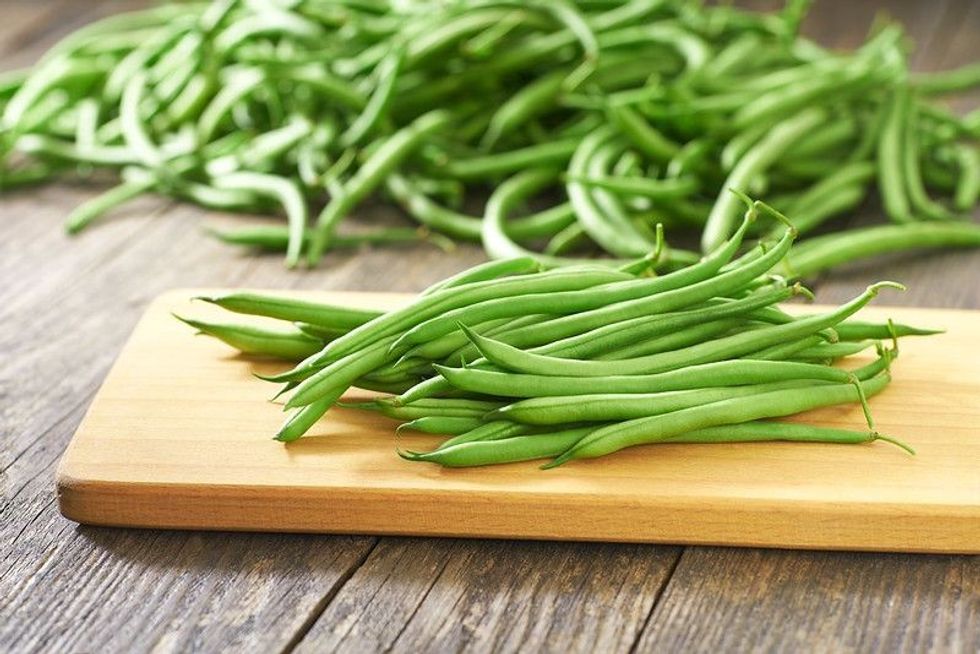 Green beans handful on a cutting board.