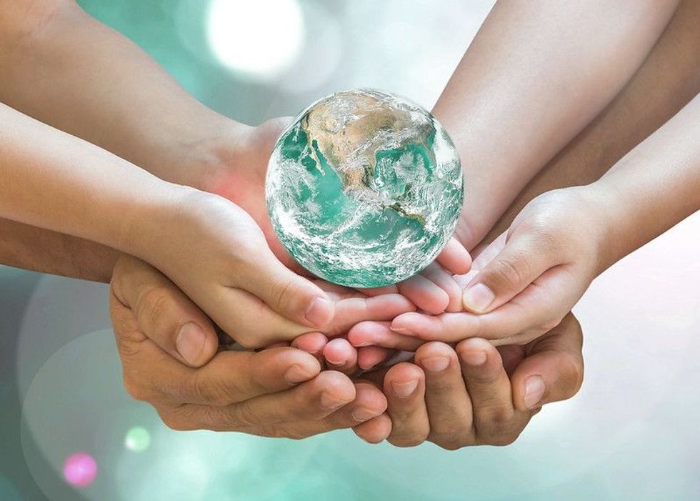 Green globe in family volunteer hands