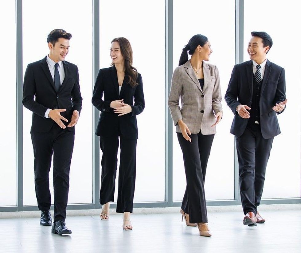 Group of young happy Asian male and female professional successful businessman and businesswoman colleagues partnership teamwork in formal business suit smiling walking side by side forward together.