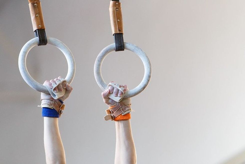 Gymnast hands with grips on gymnastic rings