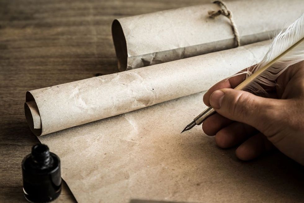 Hand writing with old quill pen on the old paper. Historical atmosphere. Empty place for a text.