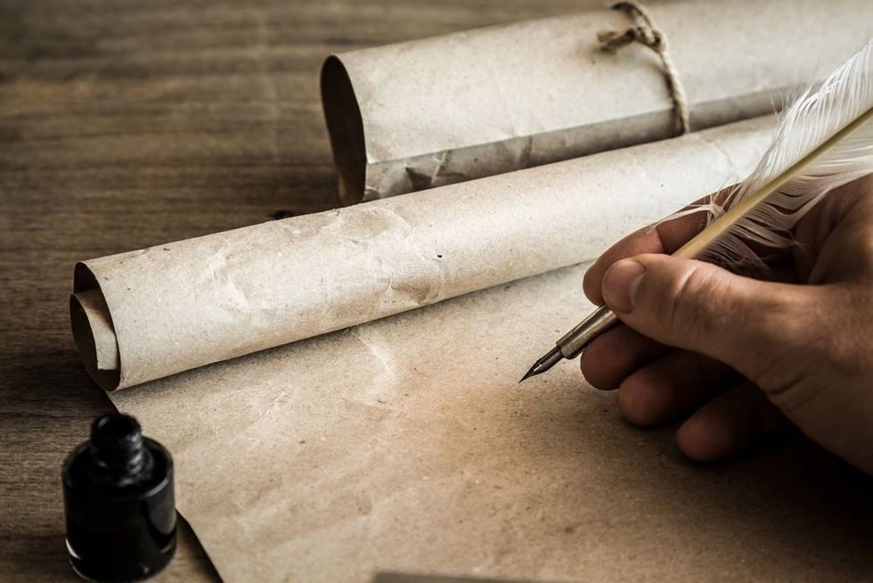 Hand writing with old quill pen on the old paper.