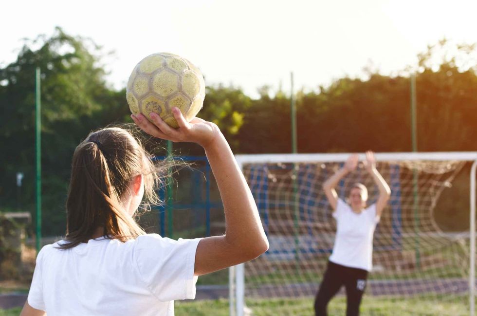 Handball players are playing game outside