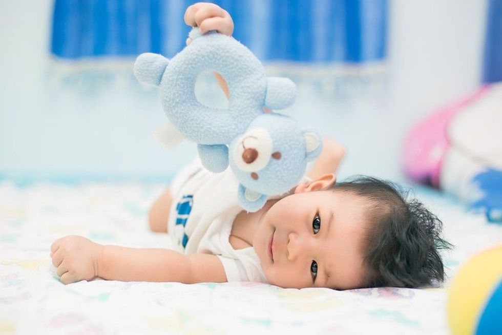 Happy baby on a bed, lying and smiling