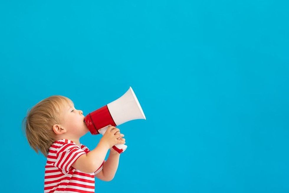 Happy child blabbing on megaphone