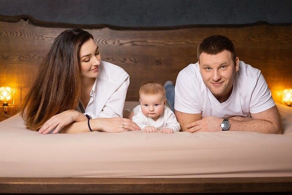 Happy family with a baby on the bed.