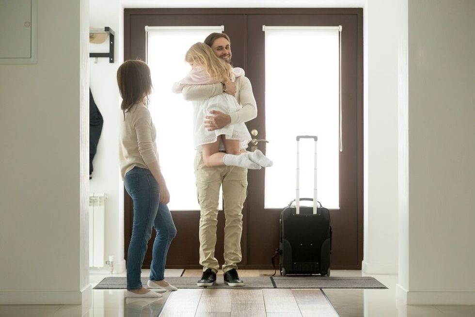 Happy father arrived home returning after business trip with baggage