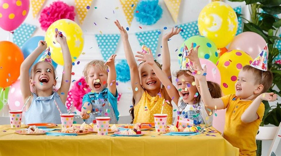 Happy kids celebrating birthday with cake and ballons