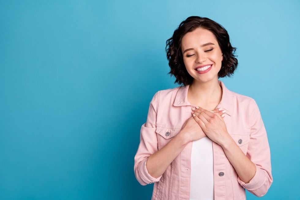 Happy lady accepting herself and smiling with eyes closed