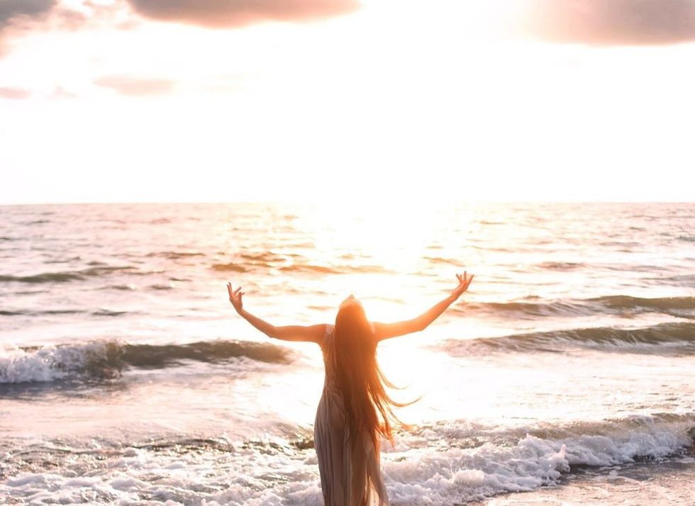Happy woman stands seashore