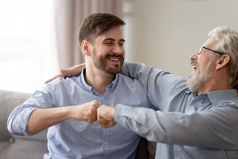 Happy young son and old father having fun together