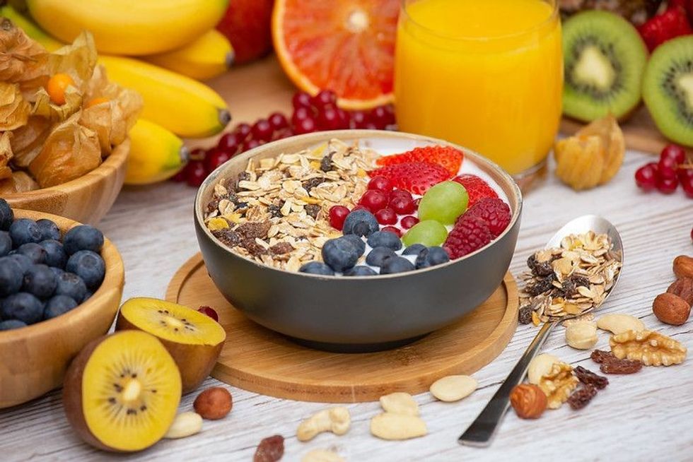 Healthy breakfast bowl of fresh fruits and oatmeal with orange juice