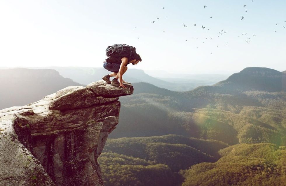 Hiker sits on a cliff