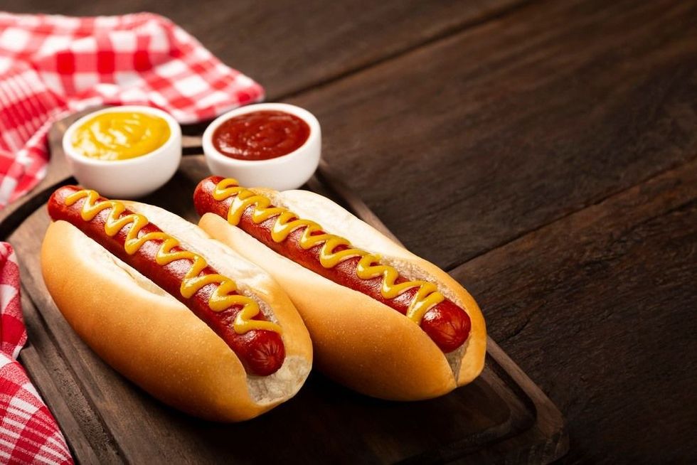Hot dog with ketchup and yellow mustard sauce.