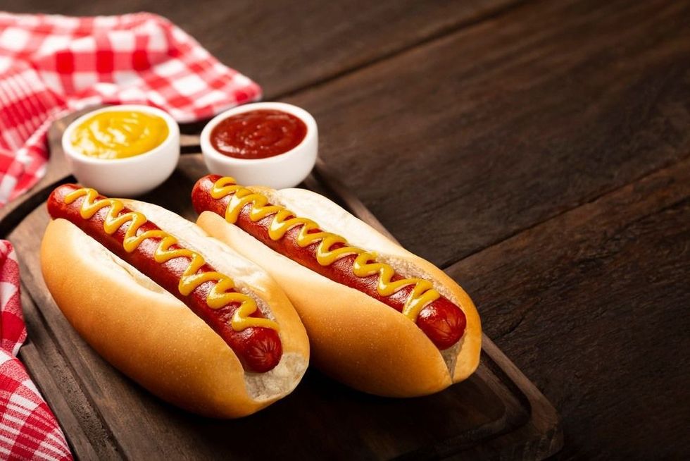 Hot dog with ketchup and yellow mustard sauce.