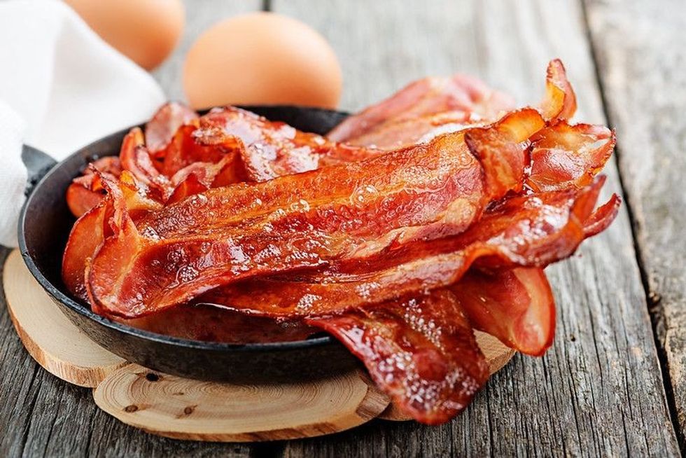 Hot fried bacon pieces in a cast iron.