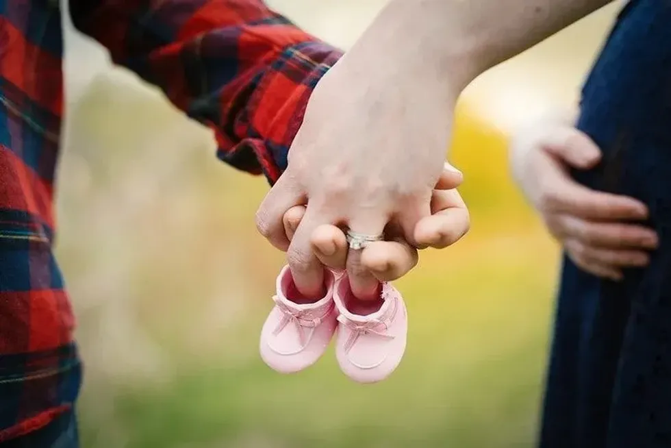 How to tell people you're pregnant could be with an announcement like this, with the parents holding pink booties.