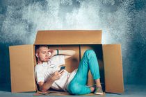 Introvert Man sitting inside box and working with phone
