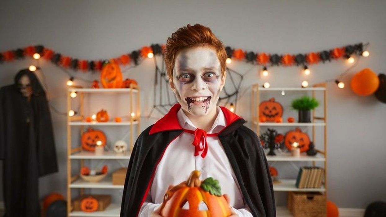 Kid in spooky Halloween vampire costume.