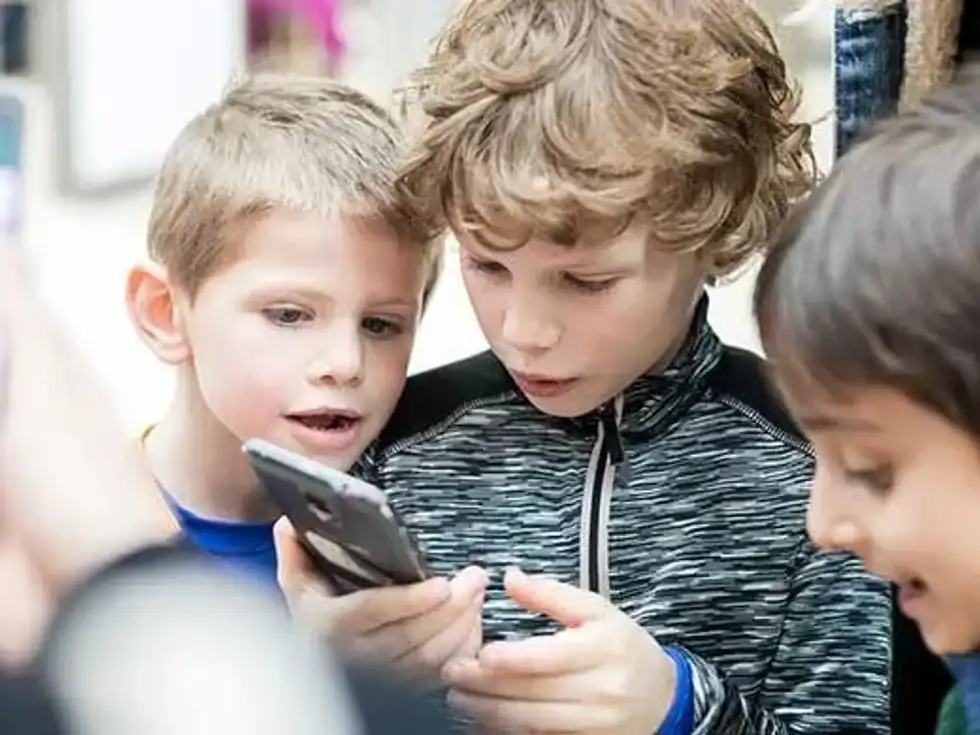 Kids looking at a phone for the text quest.