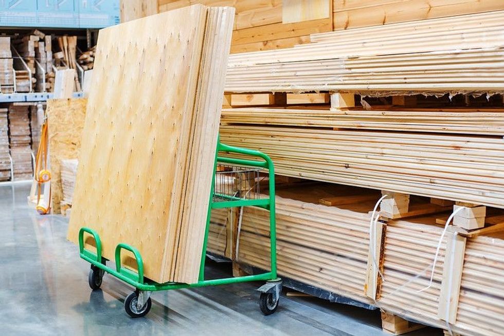 Large sheets of plywood lie on a transport cart.