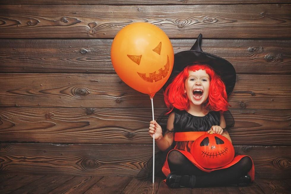Laughing girl in a witch costume in halloween.