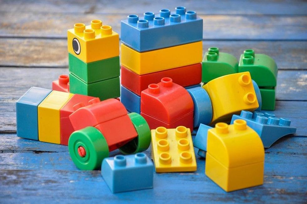 Lego plastic toy blocks on blue wood table.