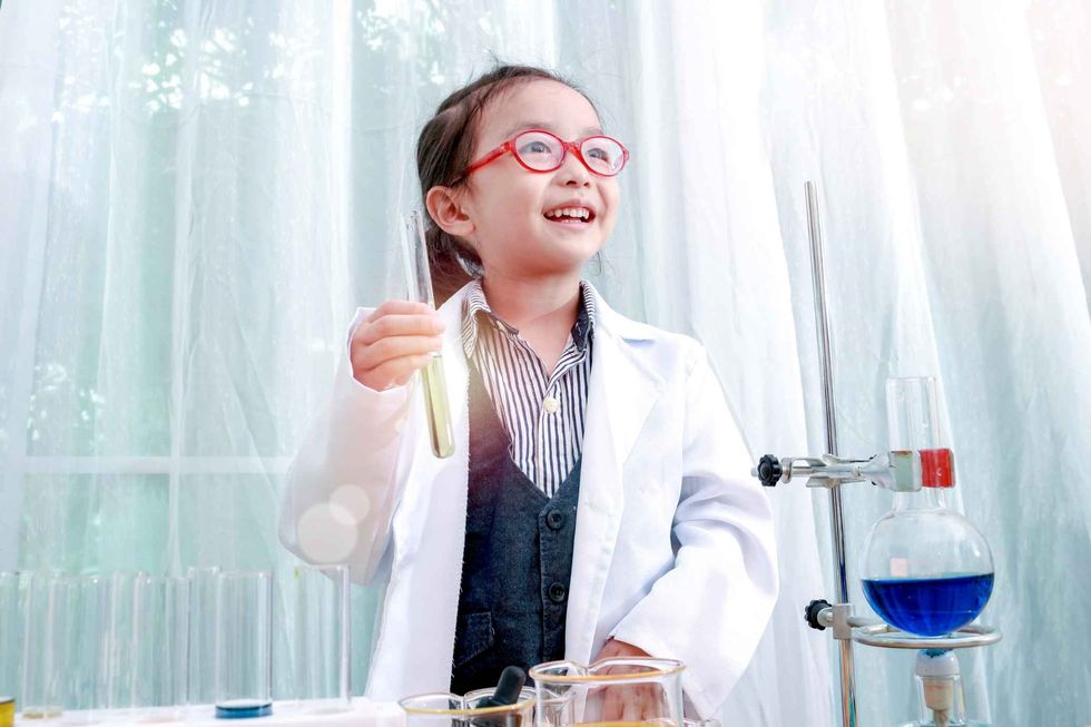 Little Asian girl doing experiments in laboratory