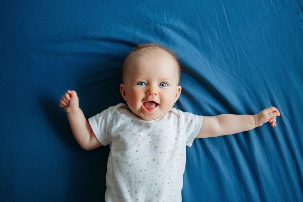 Little baby smiling while lying on blue sheet - Nicknames