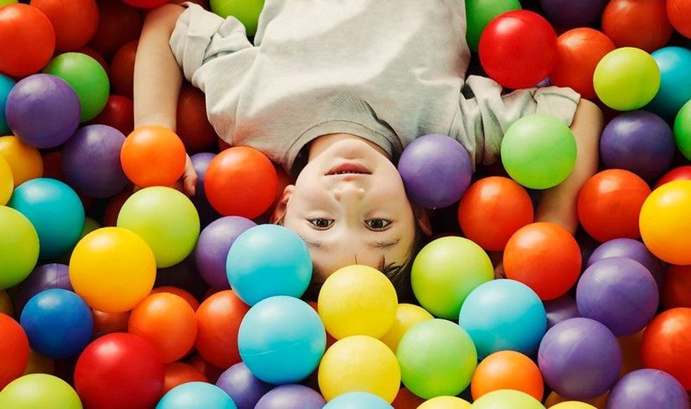 Little boy in a pool of colouful balls in ballsit