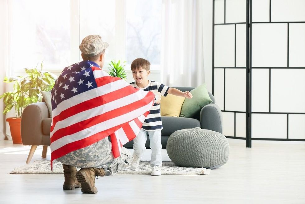 Little boy meeting his military father at home.