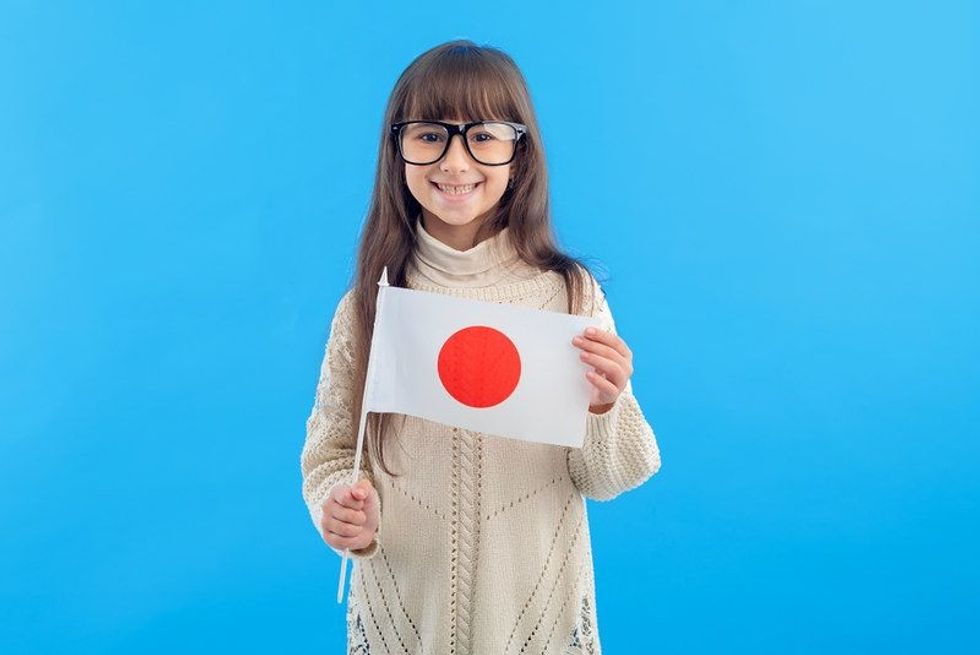 Little girl in glasses with the flag of Japan
