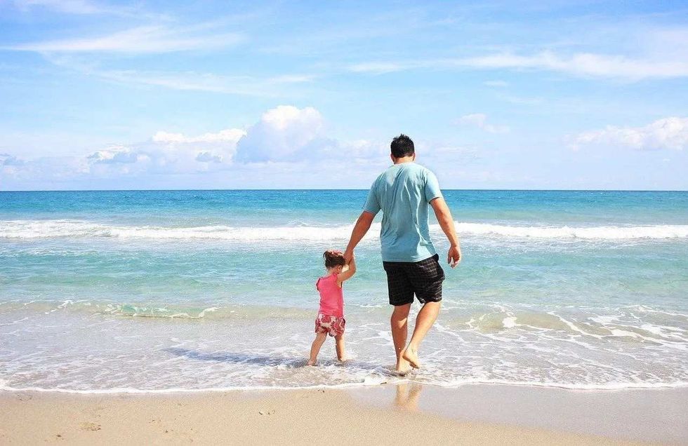 little girl on a beach holiday with her daddy