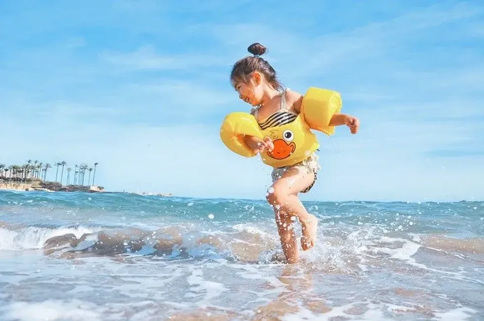 Little girl playing in the sea in armbands