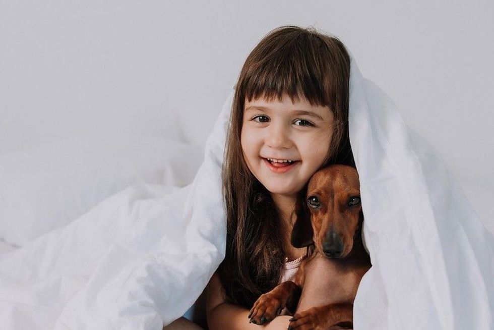 Little girl sitting with her dog
