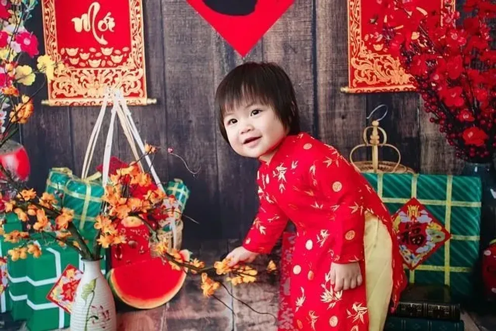 Little girl wearing traditional Vietnamese clothes for Vietnamese Lunar Year celebration
