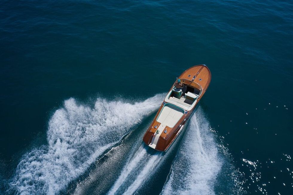 Luxurious wooden boat fast movement on dark water.