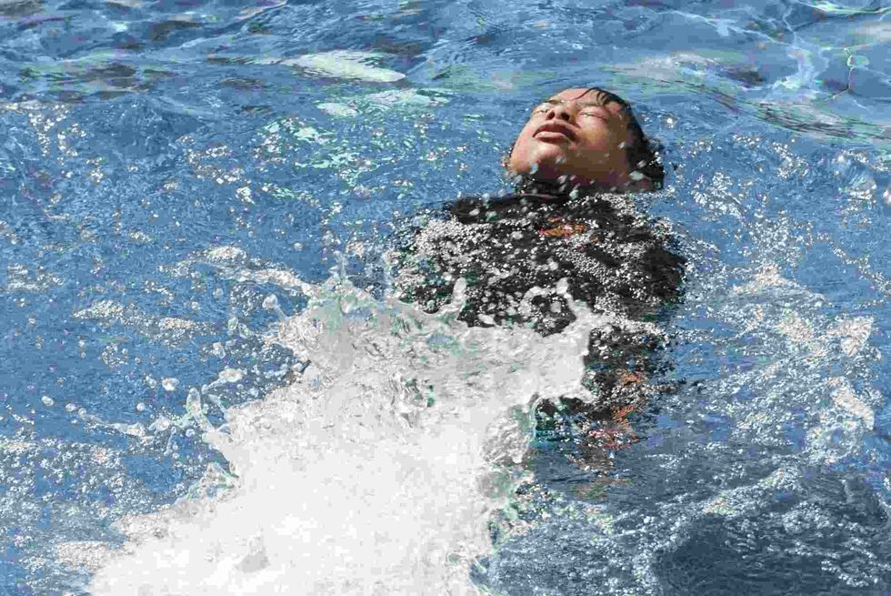  Male swimmer swimming in swimming pool.