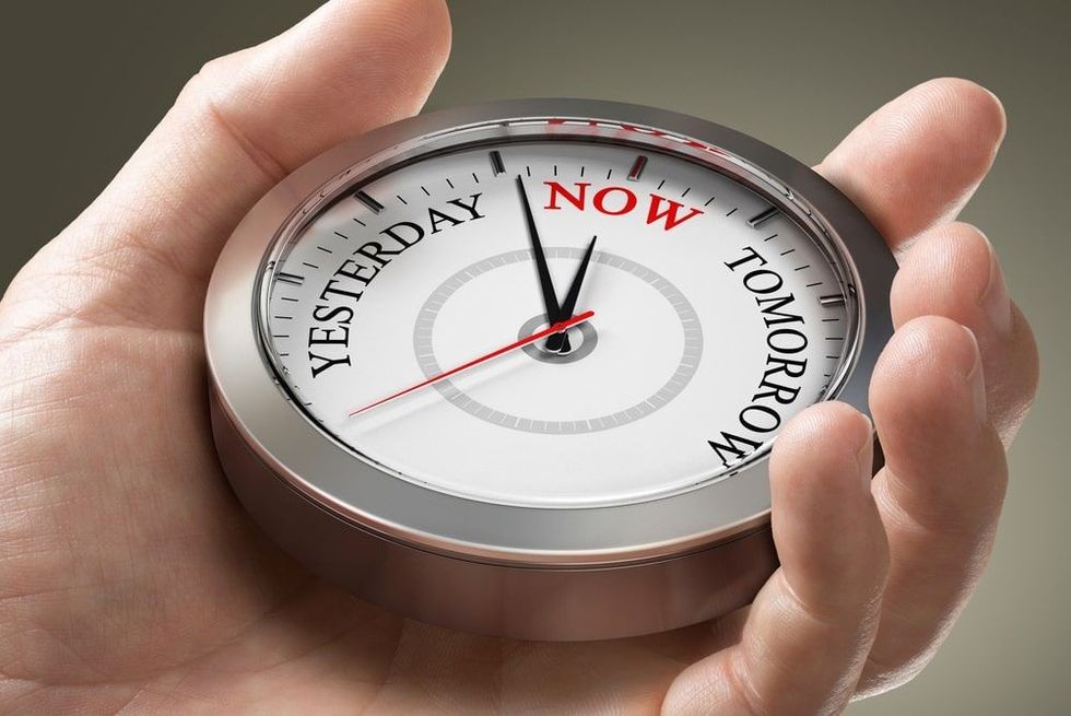 Man hand holding a conceptual clock with the words yesterday, now and tomorrow