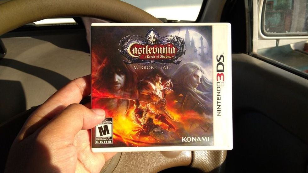 Man holding Castlevania Lord of Shadow videogame on Nintendo 3DS console in store.
