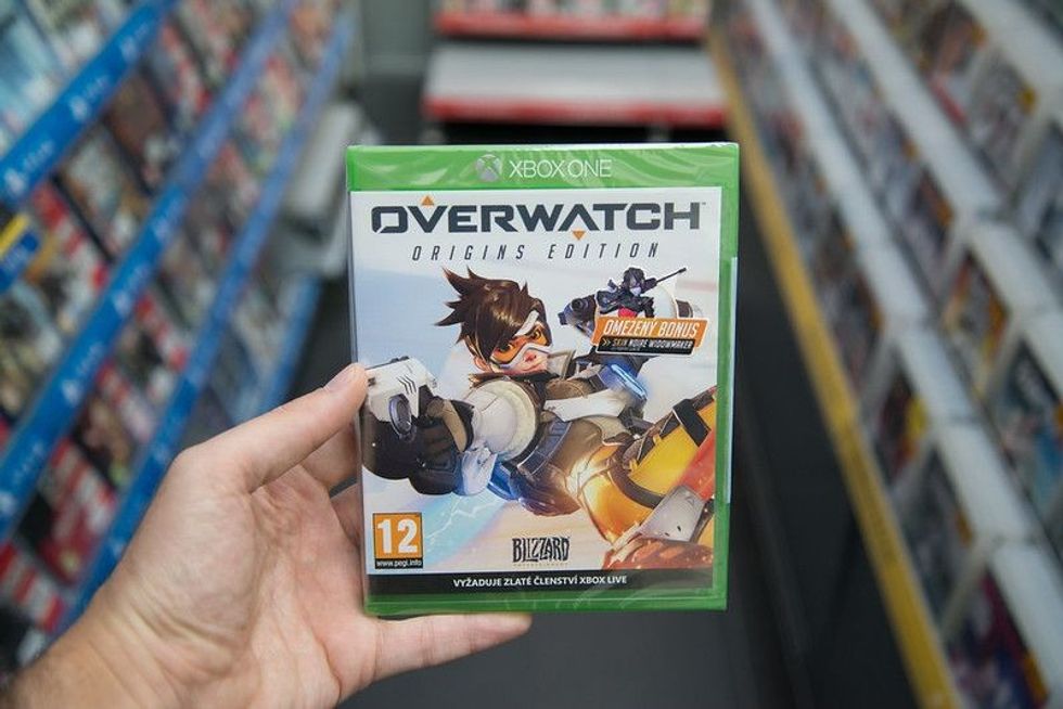 Man holding Overwatch videogame.