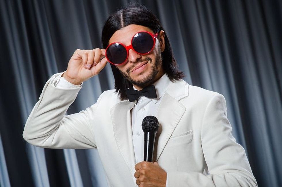 Man singing in the front of a curtain with karaoke concept.