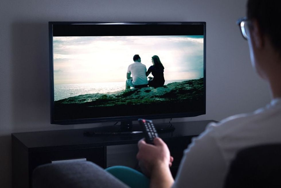 Man watching tv or streaming movie or series with smart tv at home.