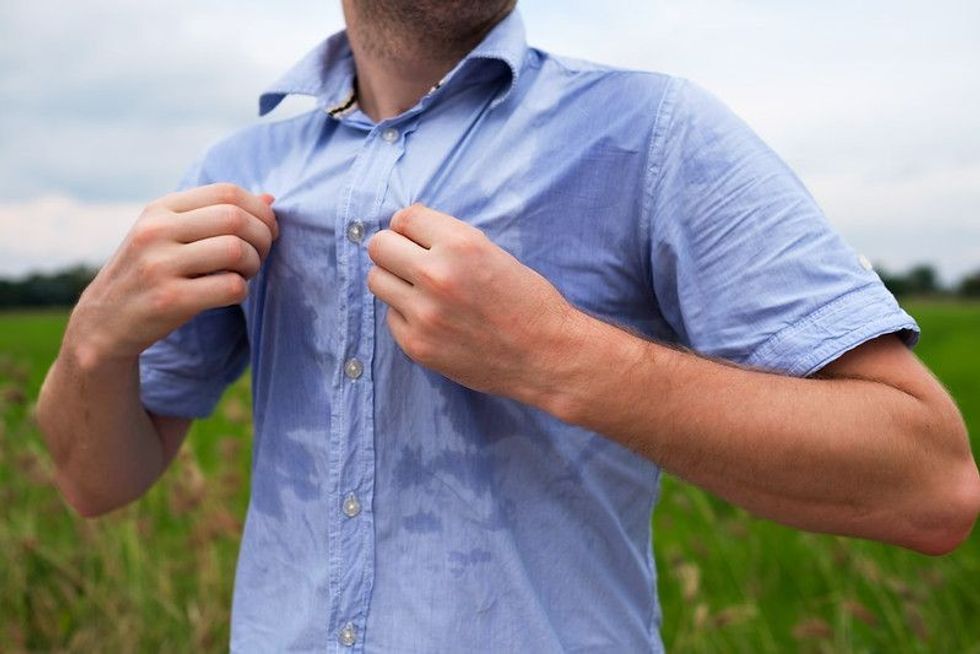 Man with a swag sweating badly in blue shirt