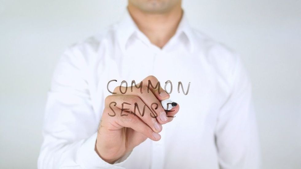 Man Writing Common Sense on a Glass.